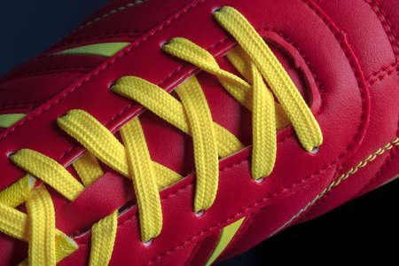The texture of a red sneaker closeup. Part of leather sports shoes