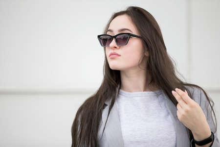 Beautiful young girl with long hair in sunglasses.Portrait of a Woman on the street