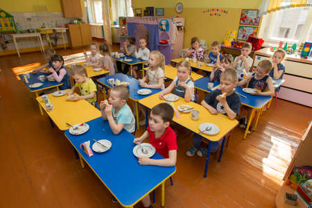 Belarus, the city of Gomel, April 25, 2019. An open day for visitors in kindergarten. Children eats in kindergarten.のeditorial素材