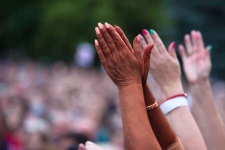 The black man raised his hands in protest. Social justice and peaceful protesting racial injustice. Black and white hands together against the background of a blurred crowd of people.の写真素材