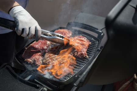 The chef's hands fry the meat.Grilled meat. Roasted piece of beef during cooking.