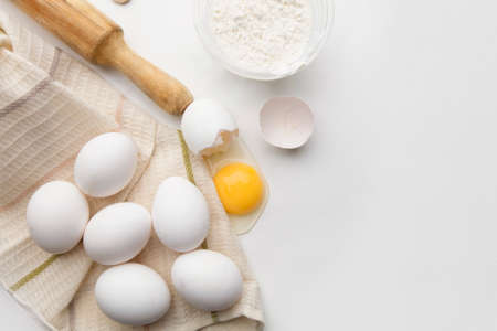 Baking cooking ingredients flour eggs rolling pin and kitchen textiles on a white background. Cookie pie or cake recipe mockupの写真素材