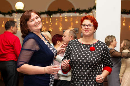 Belarus, the city of Gomil, December 22, 2018. Public canteen. Two middle-aged women are dancing in a restaurant.のeditorial素材