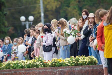 Belarus, Gomel, August 12, 2020. The streets of the city. Peoples protest against Lukashenka. A peaceful rally in Belarus against the dictator. Women with flowers raised their hands.のeditorial素材