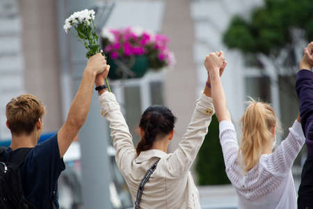 Belarus, Gomel, August 12, 2020. The streets of the city. Peoples protest against Lukashenka. A peaceful rally in Belarus against the dictator. Women with flowers raised their hands.のeditorial素材