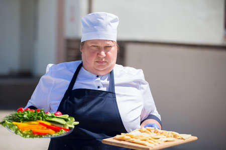 July 7, 2020 Belarus, Gomel region. City street. Woman chef with trays.のeditorial素材
