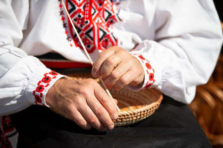 The hands of a craftsman make products from birch bark.の写真素材