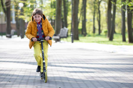 Happy boy on a scooter in the park.