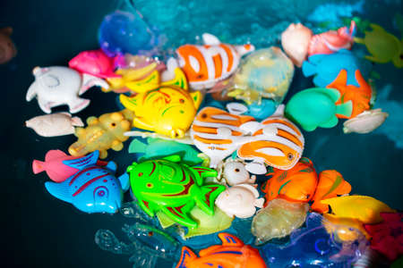 Toy colorful fish in blue water.の写真素材