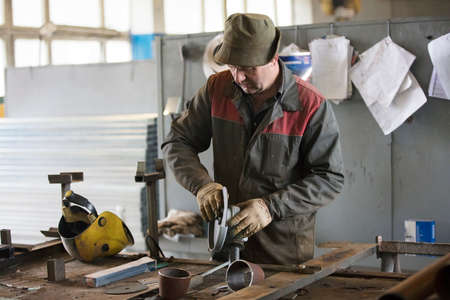 Worker in a workshop with a grinder.