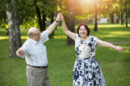 Happy elderly couple dancing. Handsome man and woman senior citizens. Husband and wife of old age for a walk.の写真素材