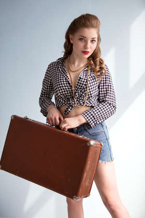 Retro pin-up girl with an old suitcase.