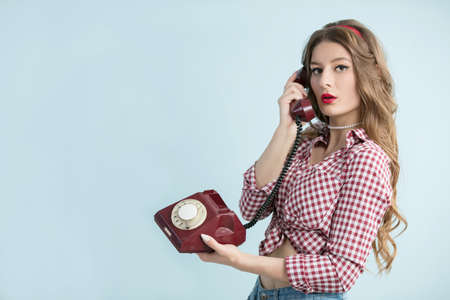 Woman in the style of the fifties. Young retro woman with an old telephone.の写真素材