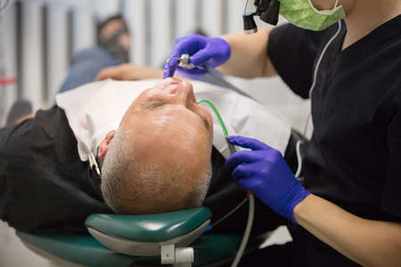 Dental office. The hands of the dentist treats the teeth of the patient.の写真素材