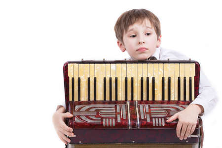 Child with a musical instrument. Elementary age boy with an accordion.の写真素材