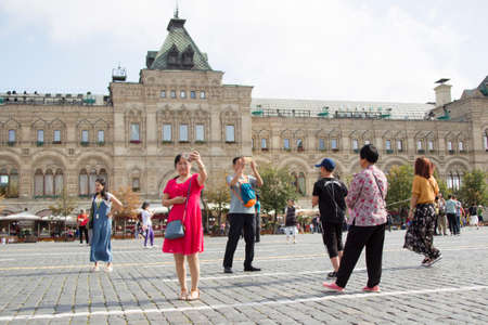 Russia, Moscow, July 29, 2018. The Red Square. Tourists on the Red Square. People in the center of Moscow. Chinese woman makes selfie on the background of the store GUMのeditorial素材
