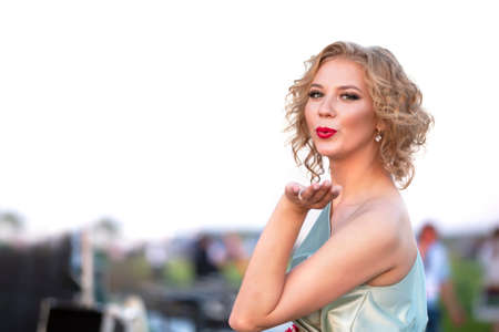 08/29/2020 Belarus, Lyaskovichi. Party in the city. Beautiful blonde girl with red lips sends an air kissのeditorial素材