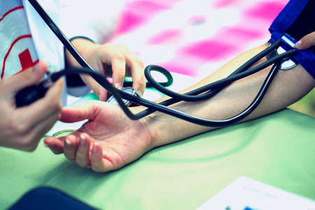 The doctor measures the pressure of the patient