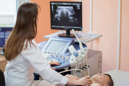 The city of Gomel, Belarus, May 31, 2017. City Hospital. Ultrasound diagnosis room. The doctor conducts an ultrasound diagnosis of the thyroid gland to the child. Thyroid ultrasoundのeditorial素材