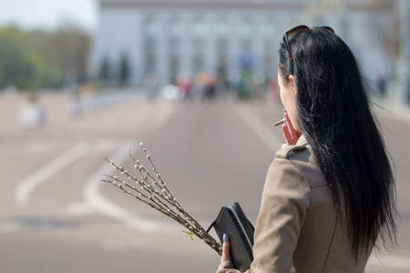 Belarus, Gomel, April 21, 2019. Palm Sunday is a church holiday.Woman with a cigarette and a willow...