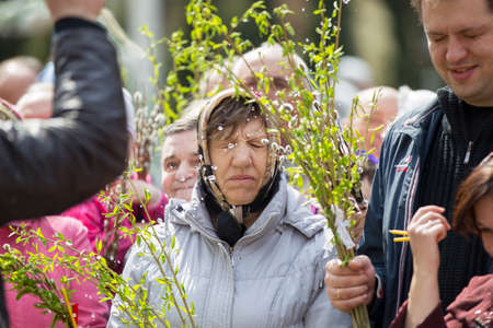 Belarus, Gomel, April 21, 2019. Palm Sunday is a church holiday.Mature ugly woman in a headscarf with willow branches.のeditorial素材