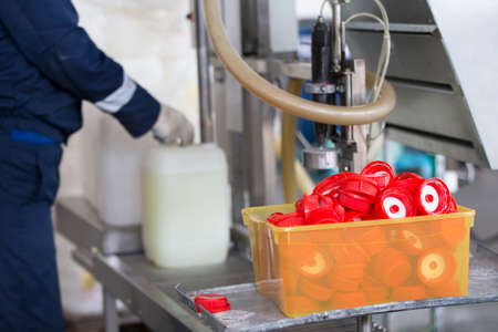 Industrial container for bottling and packaging chemicals.Hands of a worker poured into a plastic container.の写真素材