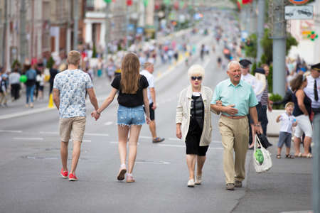 Belarus, the city of Gimel, July 03, 2019. Youth Festival.People of different ages walk the streets of the city. Elderly couple and young couple are strollingのeditorial素材