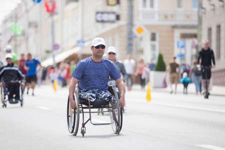 Belarus, the city of Gimel, July 03, 2019. Youth Festival.Wheelchair race.A man in a wheelchair competes in a marathonのeditorial素材