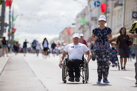 Belarus, the city of Gimel, July 03, 2019. Youth Festival.A man in a wheelchair and healthy people compete in a marathonのeditorial素材
