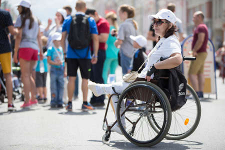 Belarus, the city of Gimel, July 03, 2019. Youth Festival.Marathon Disabled. A woman in a wheelchair against the background of ordinary peopleのeditorial素材