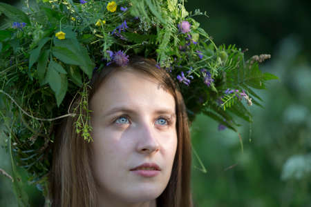 Belarus, the city of Gomel, July 07, 2018. Holiday Ivan Kupala.Portrait of a woman in a wreath of wild flowers. Slavic girl. Beautiful natural appearance of a Russian girlのeditorial素材
