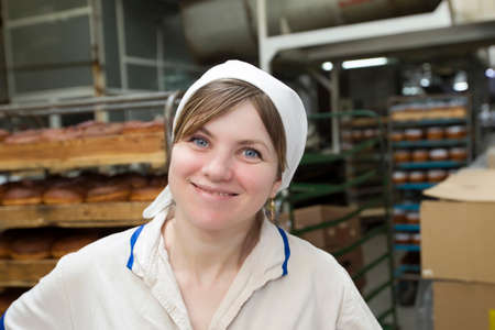 Belarus, the city of Gomil, April 25, 2019. Bakery.A bakery worker on the background of products. Beautiful woman cook at the factory in the bakery shop.のeditorial素材