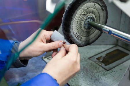 Jewelry industry. Hands make a golden decoration. Grinds the ring.の写真素材