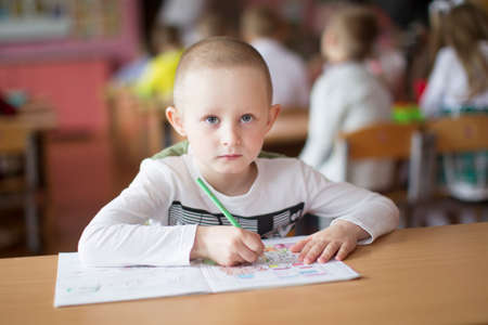 Belarus, the city of Gomil, May 10, 2019. Open day in kindergarten. Preschooler boy with a book. First grader. Portrait of a primary school student. Six year old child studyのeditorial素材