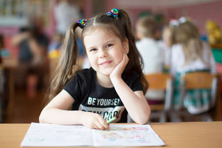 Belarus, the city of Gomil, May 10, 2019. Open day in kindergarten. Preschooler girl with a book. First-grader. Portrait of a kindergarten graduateのeditorial素材