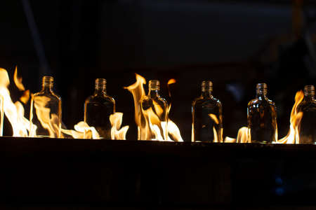 Glassworks. Glass industry. Making glass bottles. Hot bottle blanks in flameの写真素材