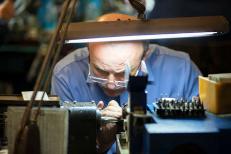 Belarus, the city of Gomil, April 24, 2019. Jewelry industry. Worker engraves diamonds.のeditorial素材