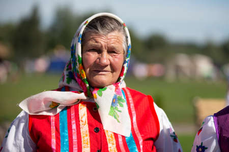 08 29 2020 Belarus, Lyakhovichi. City festival. Old Slavic woman in national dress. Russian granny in a scarf.のeditorial素材