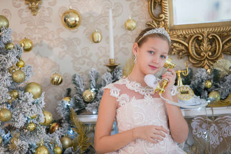 Beautiful girl at the New Year tree with a retro telephoneの写真素材