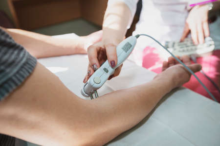 Physiotherapist performs rehabilitation after a stroke with a special device.Stroke rehabilitation