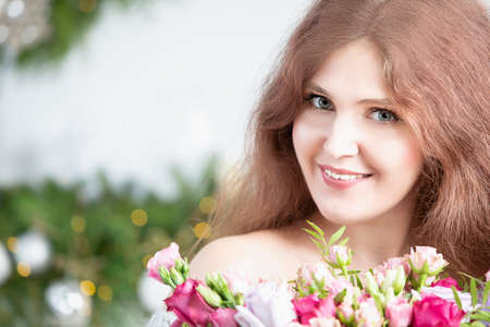 Beautiful woman with flowers. Portrait of a thirty year old girl with a bouquetの写真素材