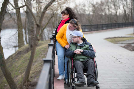 Disabled in a wheelchair with family in the park.A man with his family in a wheelchairの写真素材