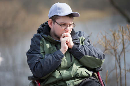 Sad guy in a wheelchair on a walk