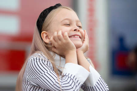 Funny little blonde girl smiles beautifully. A rado child.の写真素材