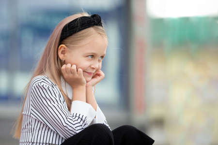 A beautiful little girl in an urban setting. A child of elementary age.の写真素材