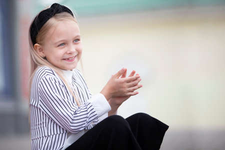 Portrait of a happy little girl with blond hair.