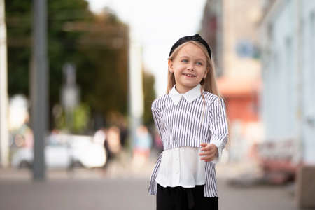 Joyful little girl on the street of the city. A child in an urban setting.の写真素材