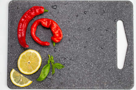 Hot red pepper and lemon on a gray background with empty placeの写真素材