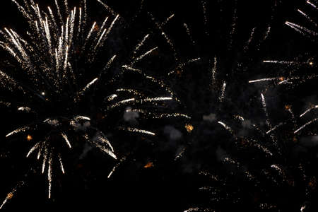 On a black background, rays and sparks of scattering fireworks.の写真素材