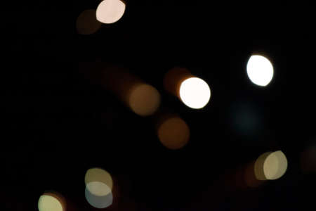 Rare light bokeh spots on a black background. Festive dark background.の写真素材